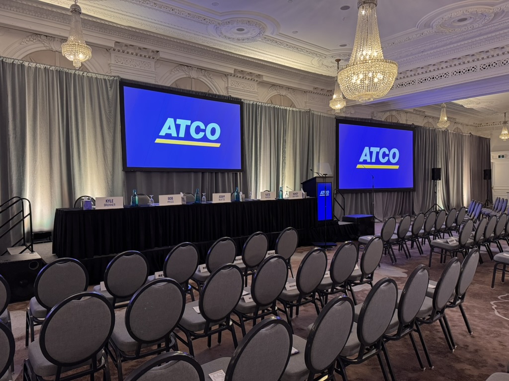 ATCO AGM ballroom set with head table and three ATCO-branded screens