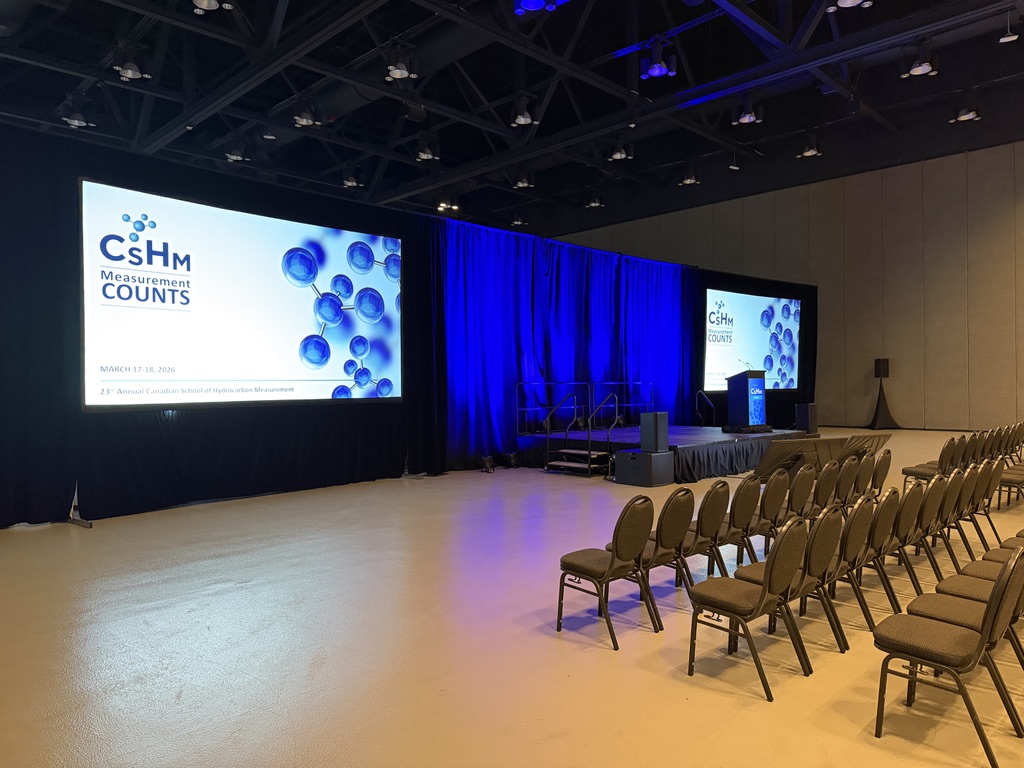 Conference stage with wide projection screen and blue drape